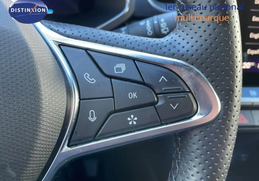 Gros plan sur les commandes au volant en cuir perforé noir du Renault Symbioz 2025, version hybride bleu iron metal.