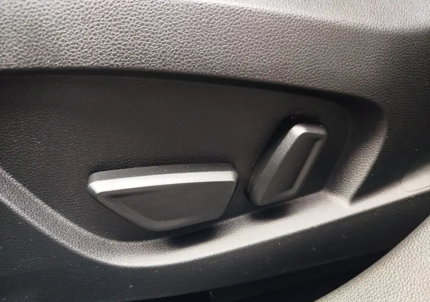 Gros plan sur les commandes de réglage électrique du siège en plastique noir dans l'habitacle du Renault Symbioz 2025.