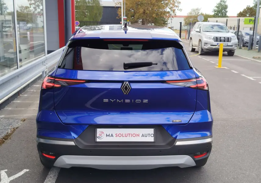 Vue arrière du Renault SYMBIOZ bleu iron metal 2025, avec feux LED fins et logo central distinctif.
