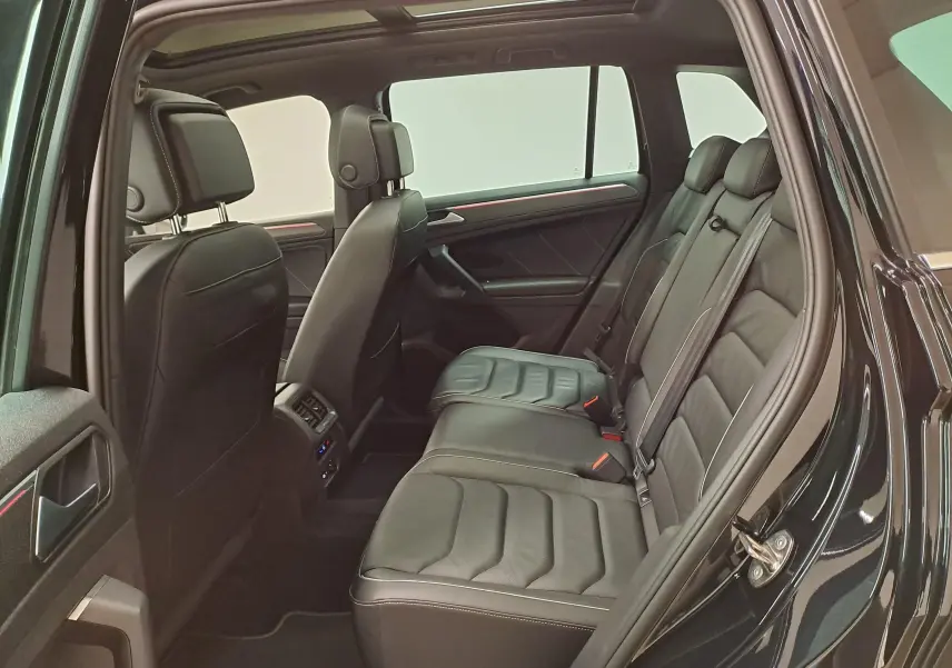Vue intérieure côté droit du Volkswagen Tiguan 2023 noir intense nacré, montrant les sièges arrière en cuir et les finitions R-Line.