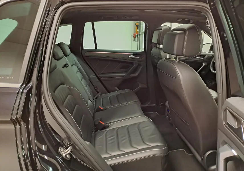 Vue intérieure côté gauche du Volkswagen Tiguan 1.4 eHybrid 2023, montrant les sièges arrière en cuir noir intense nacré.
