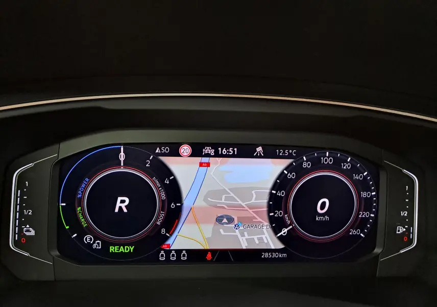 Tableau de bord numérique du Volkswagen Tiguan 2023, affichage en mode recul avec carte de navigation centrale.