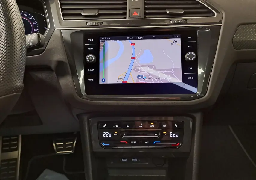 Vue rapprochée de la console centrale du Volkswagen Tiguan 2023 avec écran tactile de navigation et commandes climatisation.