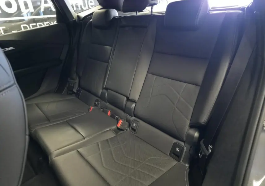 Vue intérieure sur la banquette arrière en similicuir noir perforé de la BMW Série 2 Active Tourer 218i 2023.