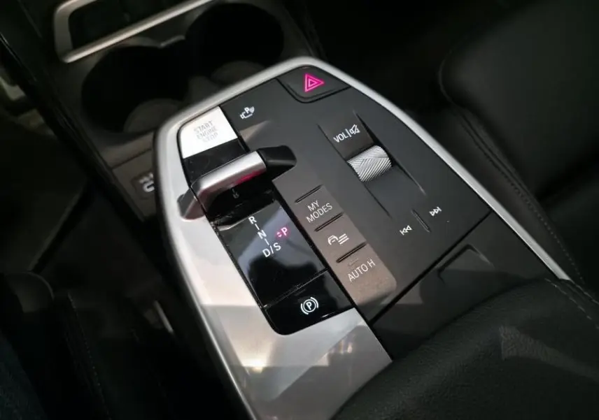 Gros plan sur la console centrale de la BMW Série 2 218i Active Tourer 2023, avec levier de vitesse et commandes intégrées.