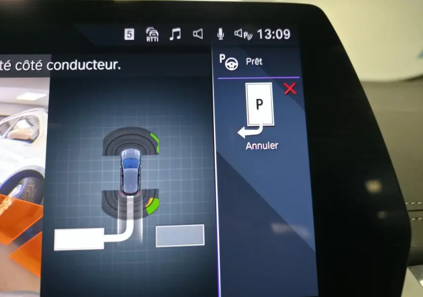 Écran tactile intérieur montrant l'assistance au stationnement de la BMW Série 2 Active Tourer gris, vue de dessus virtuelle.