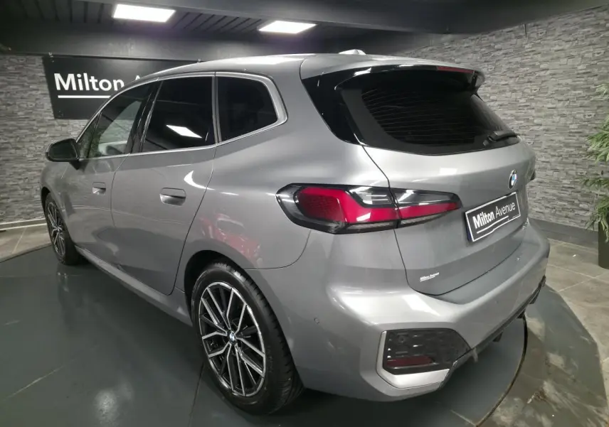 BMW Série 2 218i Active Tourer gris métallisé vue 3/4 arrière droit avec jantes alliage 18 pouces et feux LED.