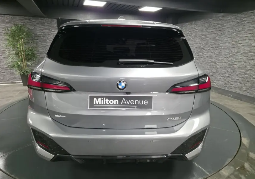 Vue arrière d'une BMW Série 2 218i Active Tourer grise métallisée avec feux LED et logo central sur hayon.
