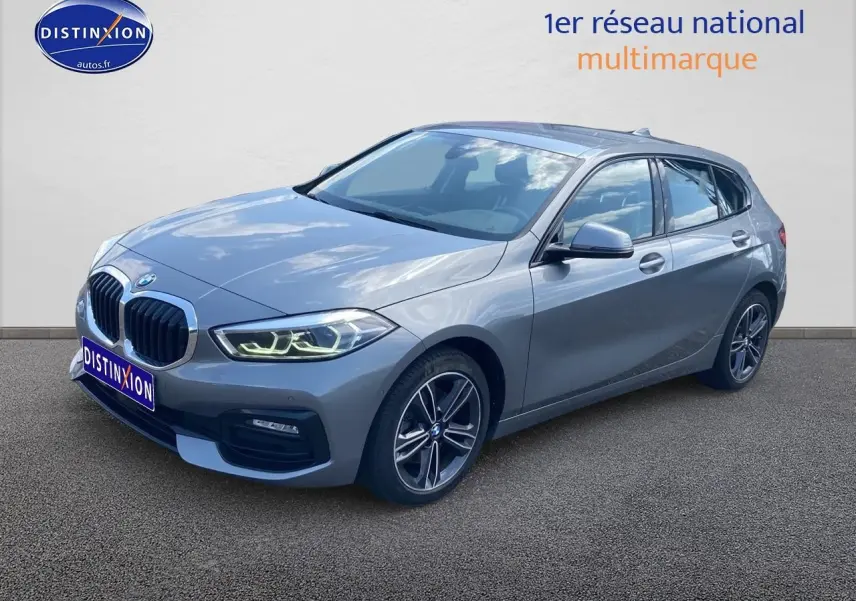 BMW Série 1 gris foncé vue 3/4 avant droit avec phares LED allumés et jantes alliage 17 pouces style 549.