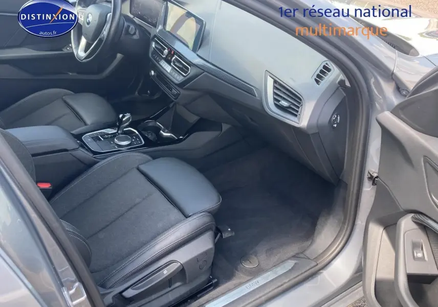 Intérieur côté passager d'une BMW Série 1 gris foncé, mettant en valeur sièges sport et tableau de bord moderne.