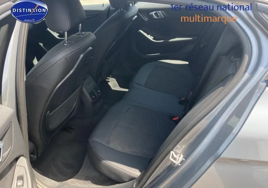 Vue intérieure côté gauche sur la banquette arrière en tissu et similicuir gris foncé d'une BMW Série 1 (f40) 118i 2023.