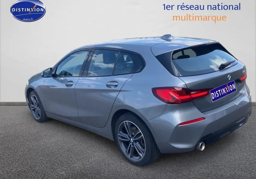 Vue 3/4 arrière droite d'une BMW Série 1 gris foncé avec jantes alliage 17 pouces et feux LED.