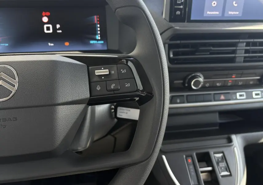 Vue rapprochée du volant et du tableau de bord noir du Citroën Jumpy 2026, avec commandes au volant et écran tactile visible.
