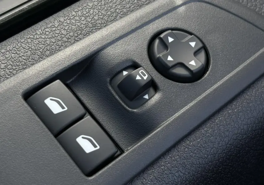 Gros plan sur les commandes de réglage des rétroviseurs et des vitres côté conducteur du Citroën Jumpy noir Perla.