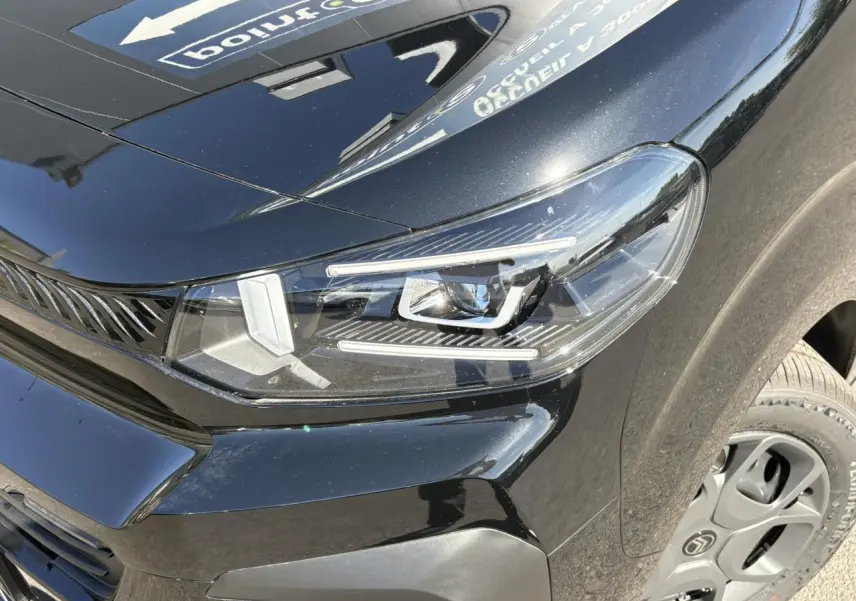 Gros plan sur le phare avant droit du Citroën Jumpy noir Perla avec jante tôle 17'' et détails du Pack Look.