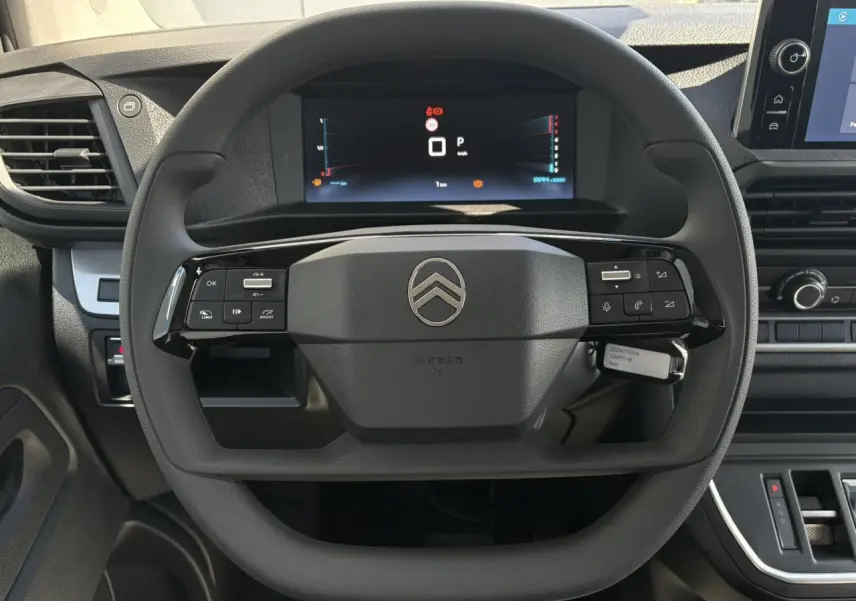 Vue intérieure centrée sur le volant noir du Citroën Jumpy 2026 avec tableau de bord numérique et écran tactile.