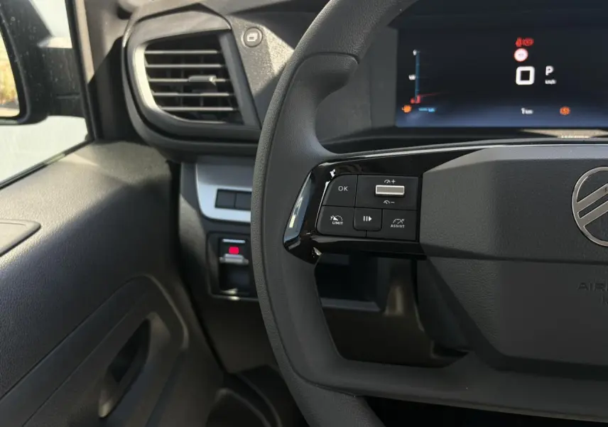 Vue rapprochée du volant côté gauche du Citroën Jumpy noir Perla avec commandes multifonctions et écran digital.