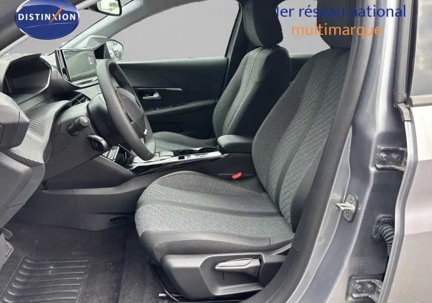 Intérieur côté conducteur de la Peugeot 208 électrique gris Artense, avec sièges tissu gris et tableau de bord moderne.