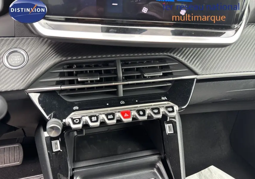 Gros plan sur la console centrale de la Peugeot 208 électrique gris Artense, avec boutons de commande et démarrage.