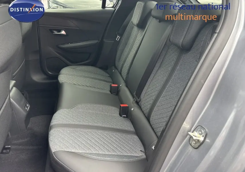 Vue côté droit des sièges arrière en tissu gris et cuir noir d'une Peugeot 208 électrique gris Artense métal, porte ouverte.