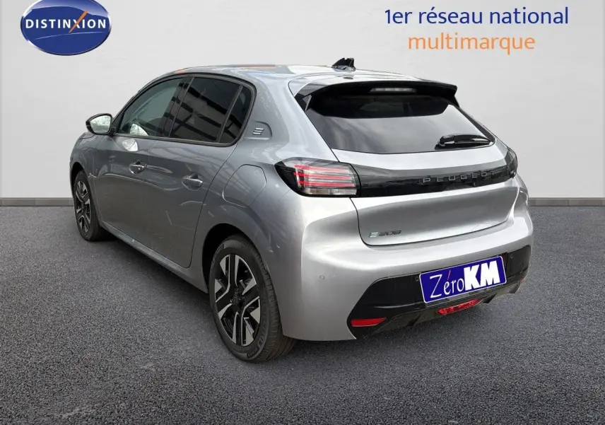 Vue 3/4 arrière droite d'une Peugeot 208 électrique gris Artense métal avec jantes noires et vitres teintées.