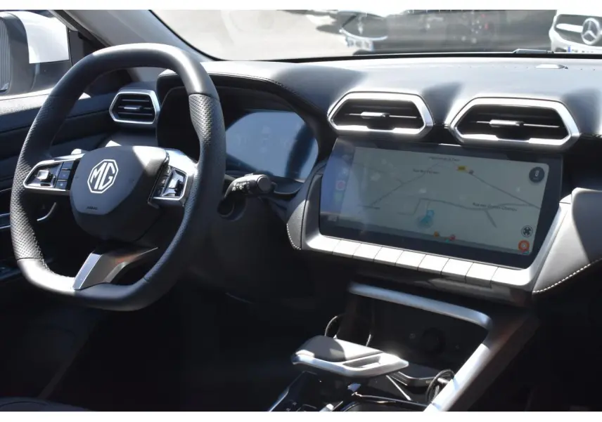 Vue intérieure du tableau de bord et volant du MG ZS blanc 2026 avec écran tactile et commandes au volant.