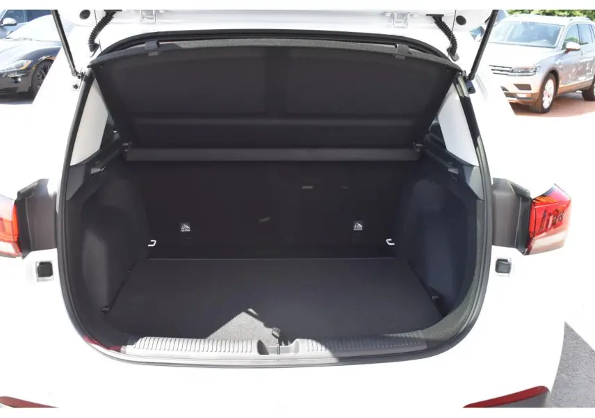 Coffre ouvert vu de l'arrière d'un MG Motor ZS blanc 2026, avec feux arrière et intérieur du coffre noir visible.