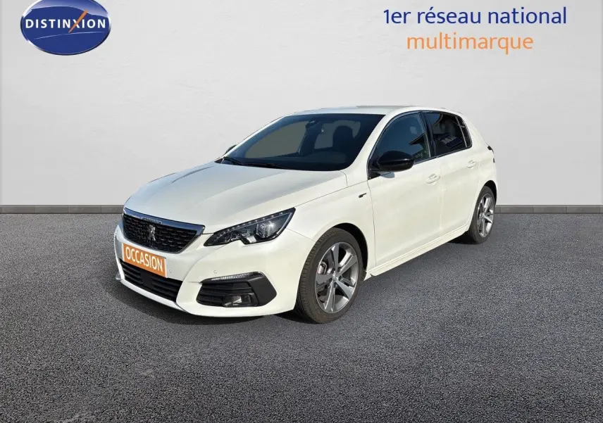 Peugeot 308 blanc nacré vue 3/4 avant droit, jantes alliage et calandre noire avec logo lion visible.