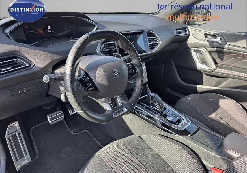 Intérieur de la Peugeot 308 GT 2021 vu côté conducteur, volant cuir perforé et console centrale moderne.