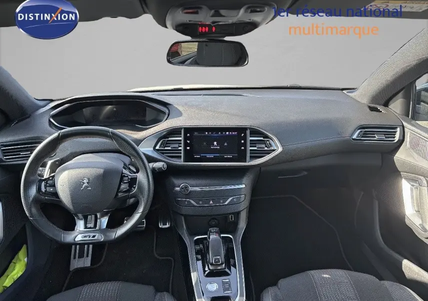 Vue intérieure avant de la Peugeot 308 GT 2021 avec tableau de bord moderne et volant cuir perforé noir.