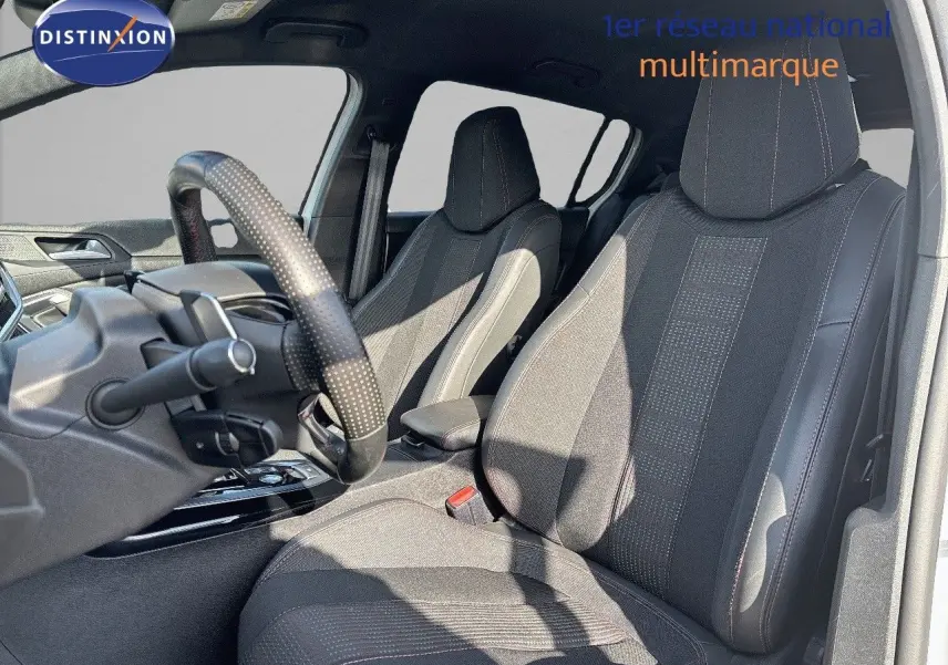 Intérieur de la Peugeot 308 GT 2021 vu côté conducteur, sièges en tissu noir avec surpiqûres rouges.