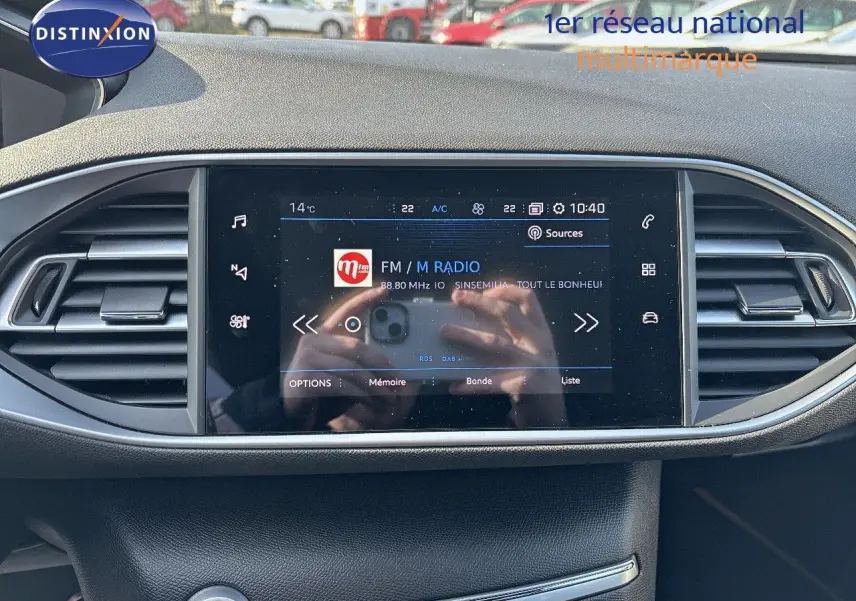 Écran tactile central du tableau de bord de la Peugeot 308 1.2 PureTech 130ch GT, affichant une radio FM.