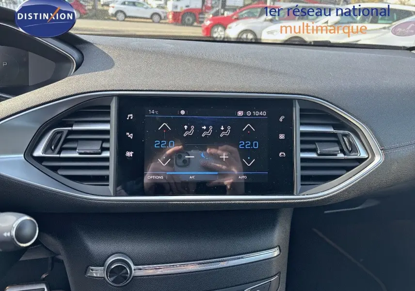 Tableau de bord de Peugeot 308 blanc nacré 2021, vue frontale centrée sur l'écran tactile et aérateurs chromés.