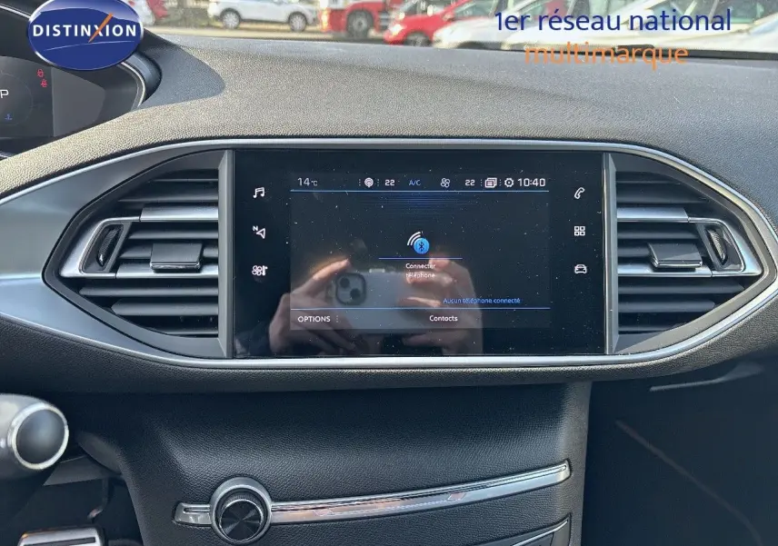 Écran tactile central du tableau de bord d'une Peugeot 308 GT 2021, avec commandes climatisation et aérateurs.