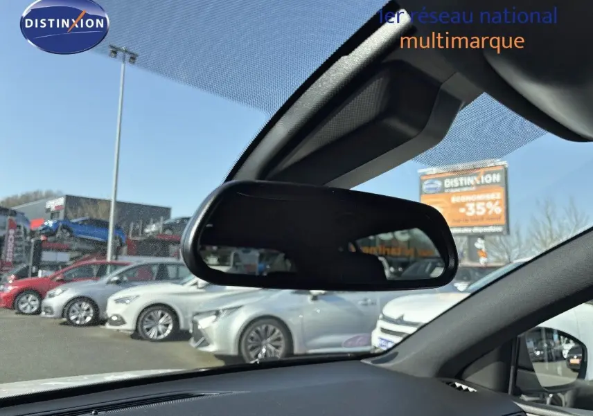 Vue depuis l'intérieur montrant le rétroviseur central et en arrière-plan une Peugeot 308 blanc nacré en extérieur.