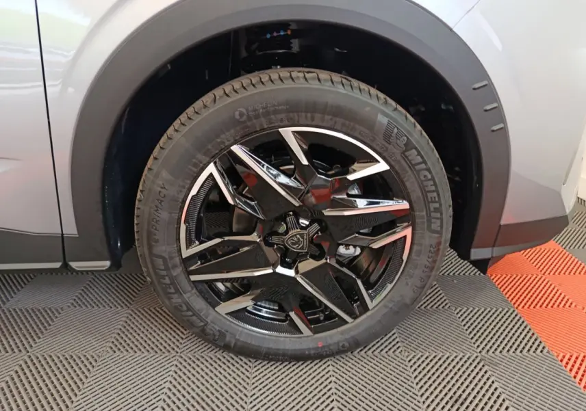 Gros plan sur la roue avant gauche du Peugeot 3008 gris clair, avec jante noire et argentée au design moderne.