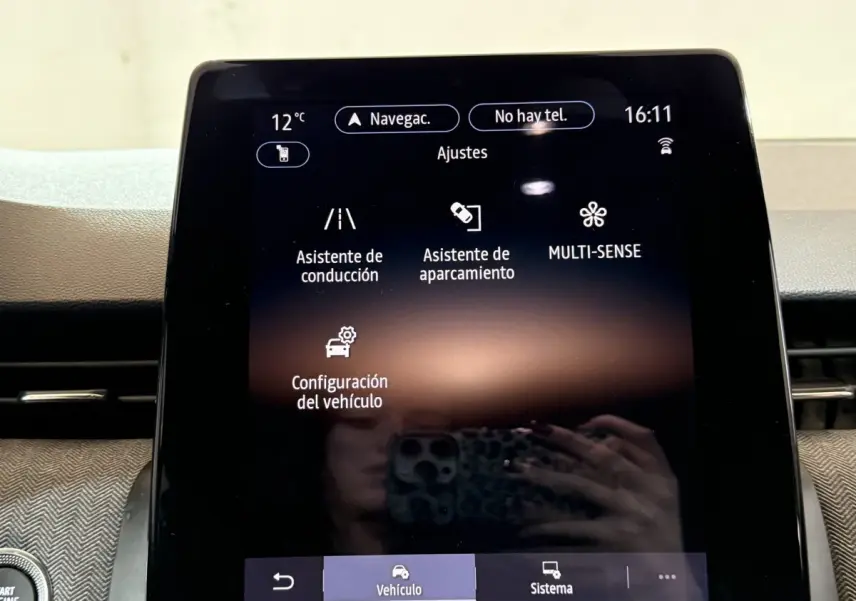 Écran tactile central affichant les réglages du véhicule dans l’habitacle d’une Renault Clio rouge.