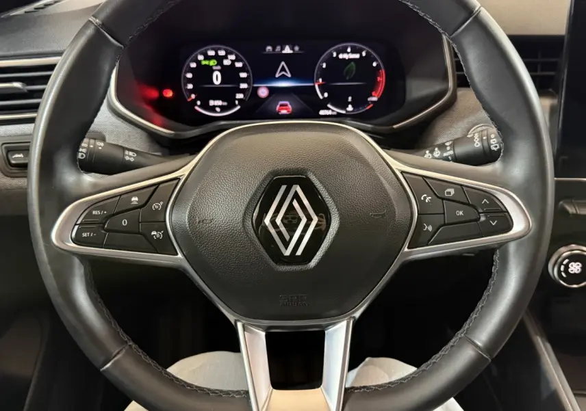 Vue rapprochée du volant en cuir noir de la Renault Clio Techno TCe 90 2024 avec tableau de bord numérique.