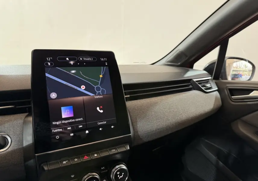 Vue intérieure côté passager de la Renault Clio Techno TCe 90 2024 rouge, avec écran tactile central et tableau de bord texturé.