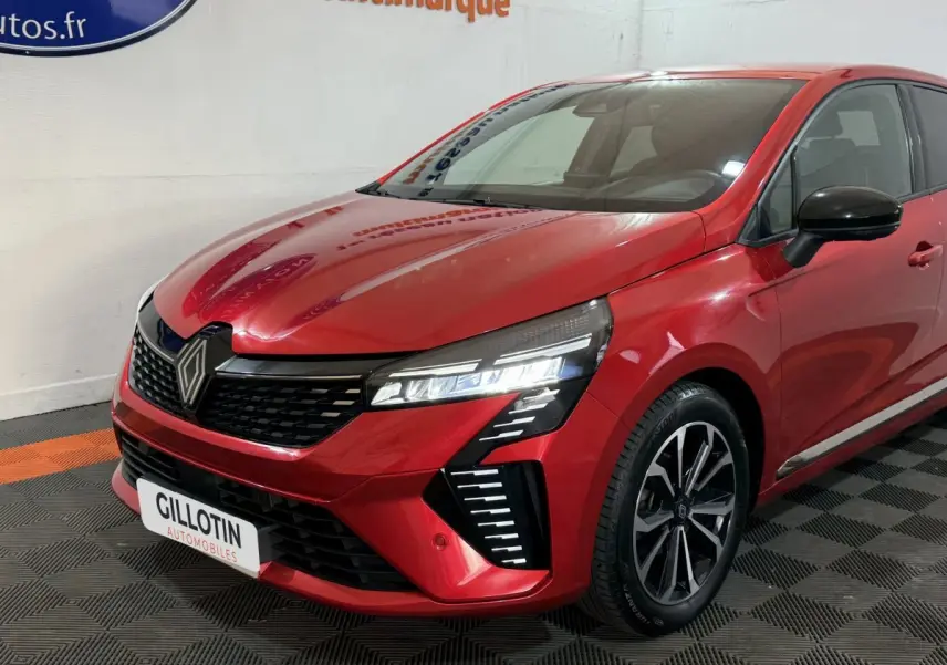 Renault Clio Techno TCe 90 rouge vue 3/4 avant droit, avec phares LED et jantes alliage noires.