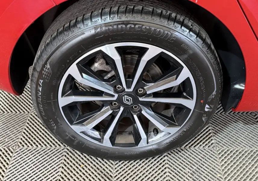 Gros plan sur la roue avant droite de la Renault Clio rouge 2024 avec jante alliage noire et argentée.