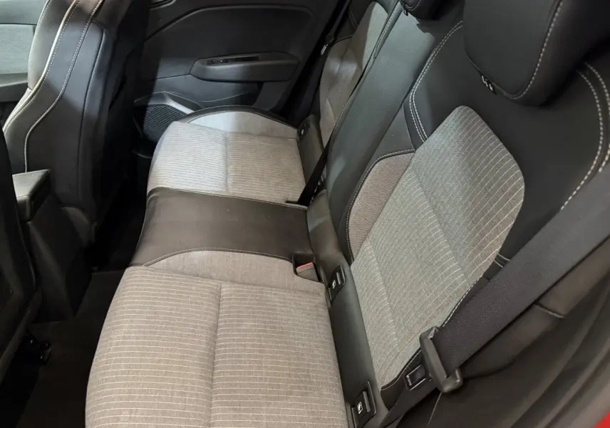 Vue intérieure côté arrière droit montrant la banquette bicolore gris clair et noir de la Renault Clio Techno TCe 90 rouge 2024.