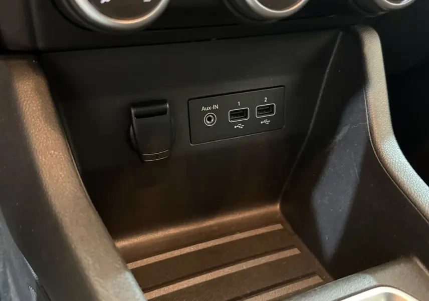 Gros plan sur la console centrale noire de la Renault Clio Business avec ports USB et prise Aux-IN visibles.