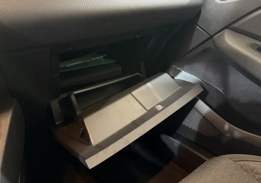 Vue intérieure côté passager de la boîte à gants ouverte dans une Renault Clio Business blanche de 2021.