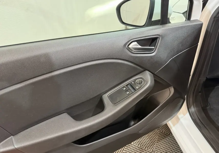 Vue rapprochée de la porte avant gauche noire de la Renault Clio Business blanche, avec commandes de vitres et rétroviseur.