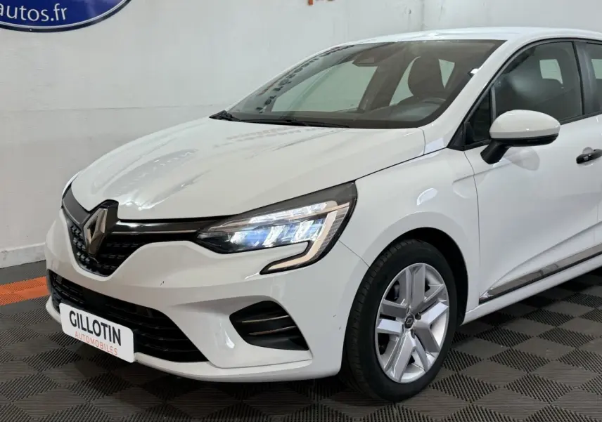 Renault Clio Business blanche vue 3/4 avant droit, avec phares LED allumés et jantes alliage visibles.