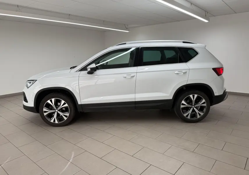 SEAT Ateca blanc Nevada vu de profil côté gauche, avec jantes alliage et barres de toit noires.