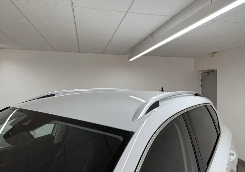 Vue en plongée du toit blanc métallisé du SEAT Ateca 2023 avec barres de toit et vitres latérales teintées.