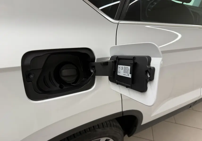 Vue rapprochée de la trappe à carburant ouverte côté gauche d’un SEAT Ateca blanc Nevada 2023.