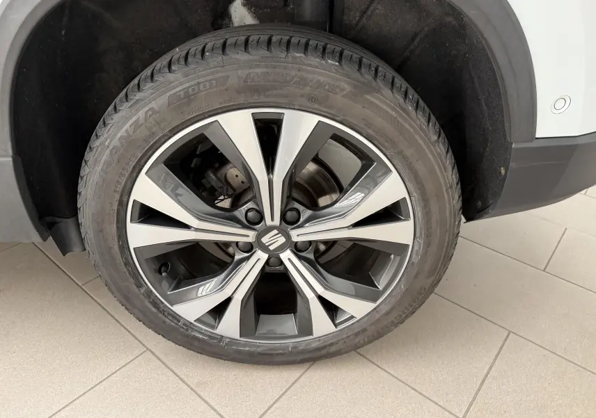 Gros plan sur la roue avant droite du SEAT Ateca blanc Nevada, avec jante alliage 18 pouces au design moderne.